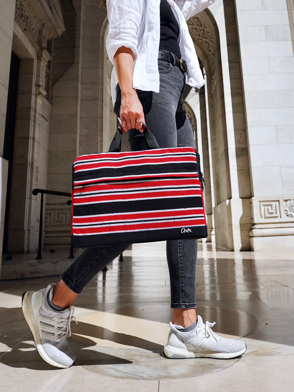 A person walking with a laptop bag with red, black and white stripes and has handles. The name of the laptop bag is Davao.
